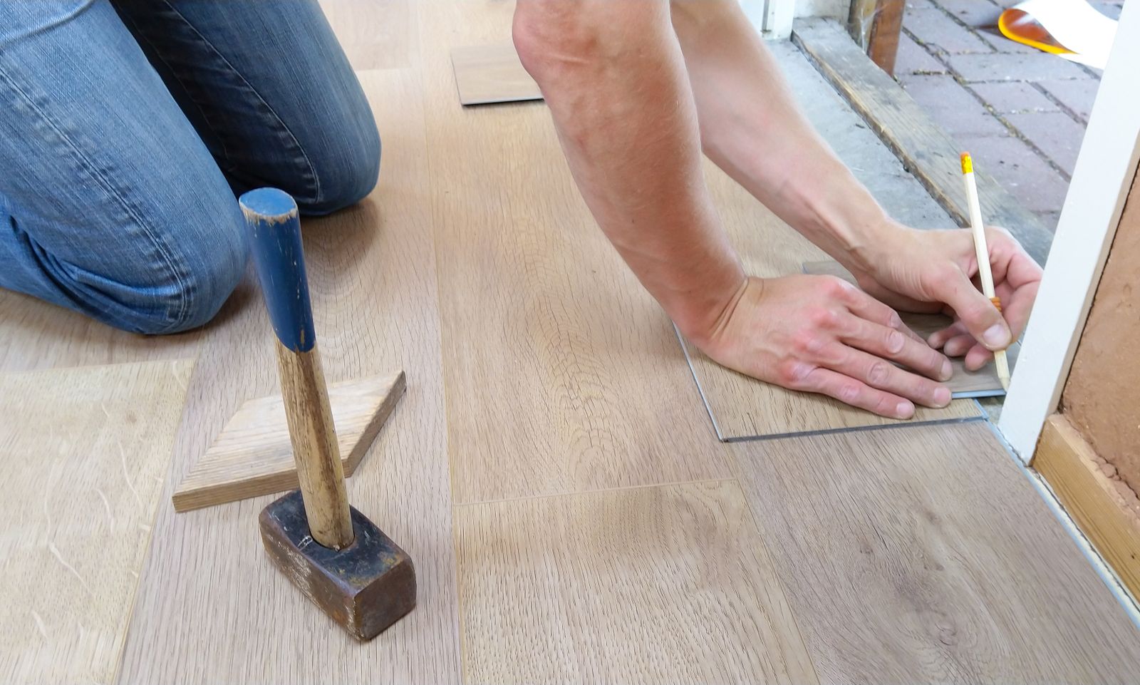 Installer laying luxury vinyl plank flooring — flooring installation Northwest Indiana
